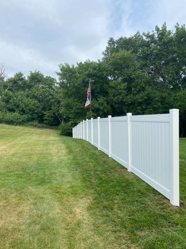 White vinyl privacy fence installed across a large yard
