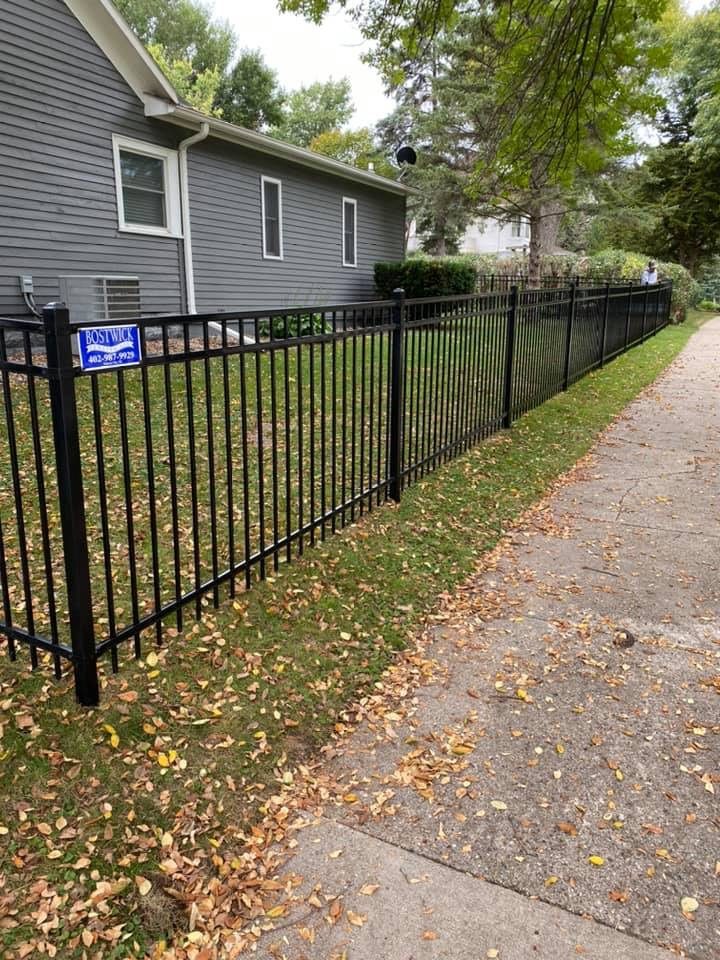Black ornamental fence installed along a residential walkway