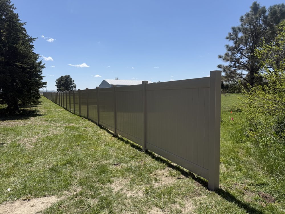 Vinyl privacy fence installed along a driveway
