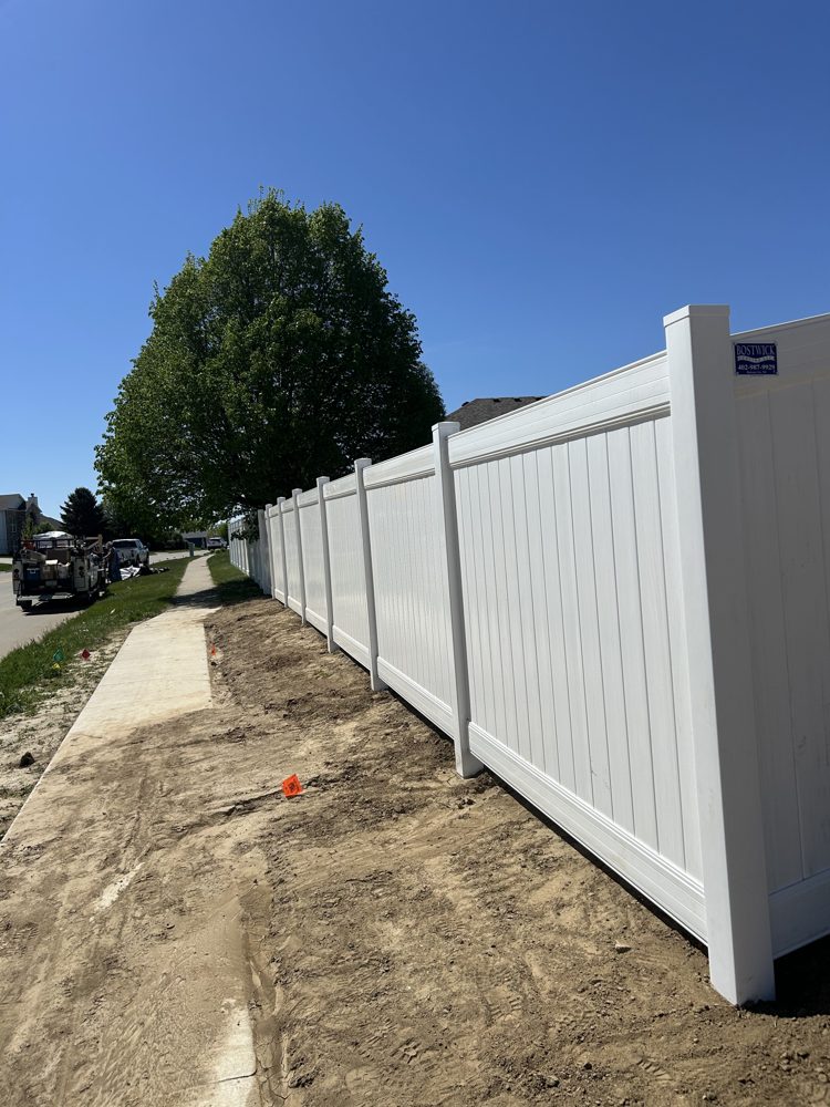 Black ornamental fence installed along a sidewalk