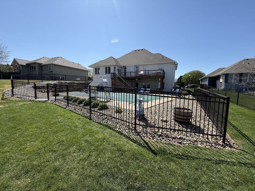 Ornamental fence installed around a backyard pool area