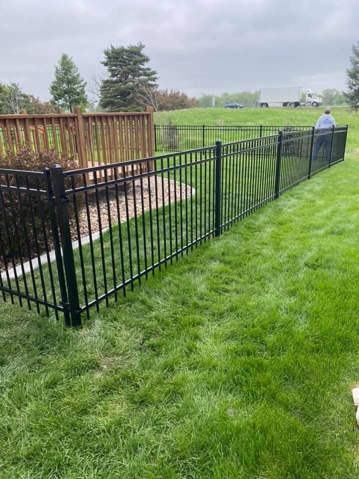 Black ornamental fence installed along a lawn