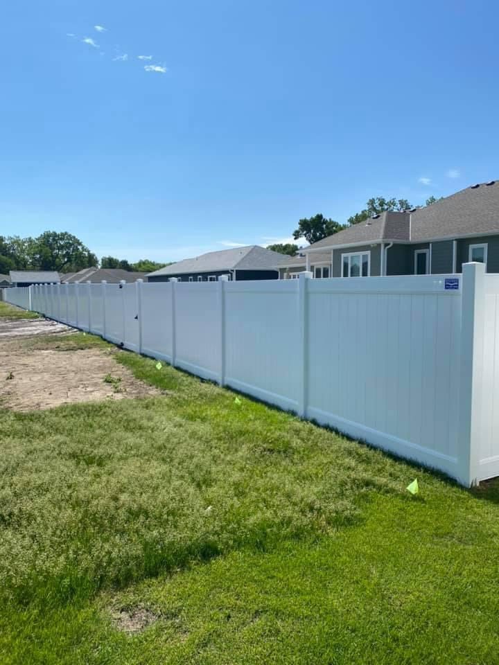 White vinyl privacy fence installed along a new subdivision lot