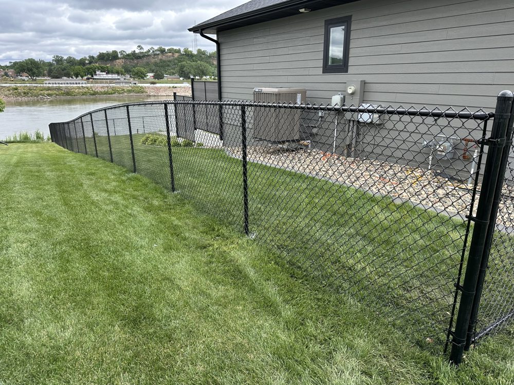 Tan vinyl privacy fence installed beside a home