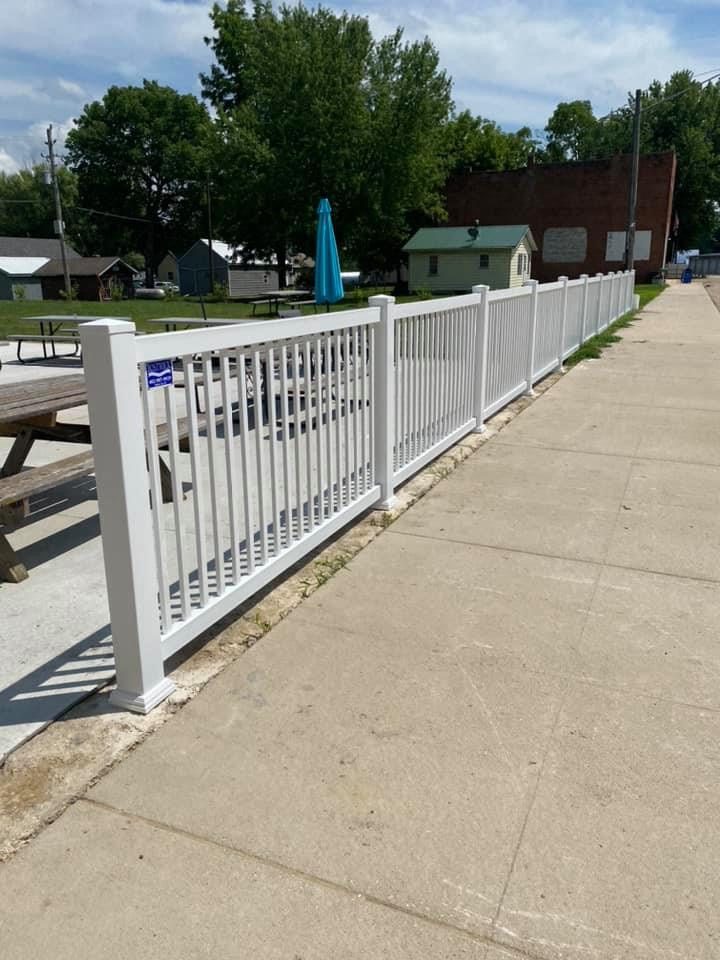 White vinyl picket fence installed along a sidewalk