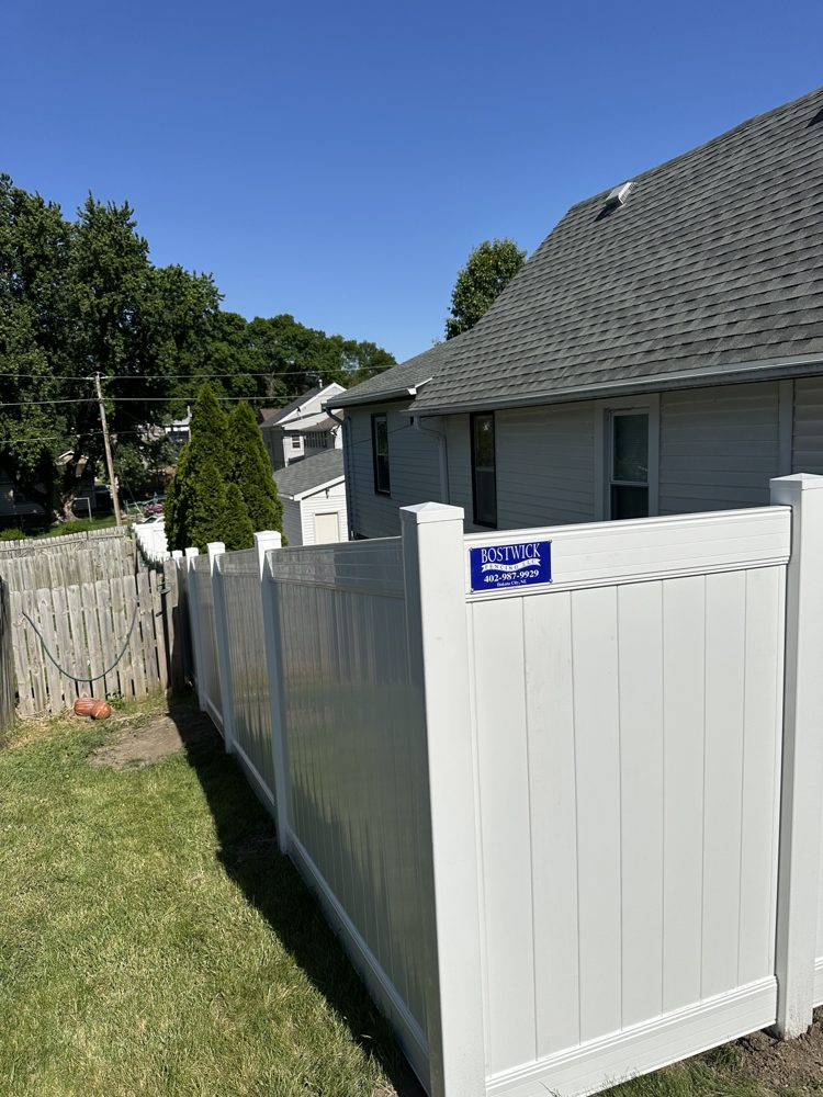 White vinyl privacy fence installed along a side yard