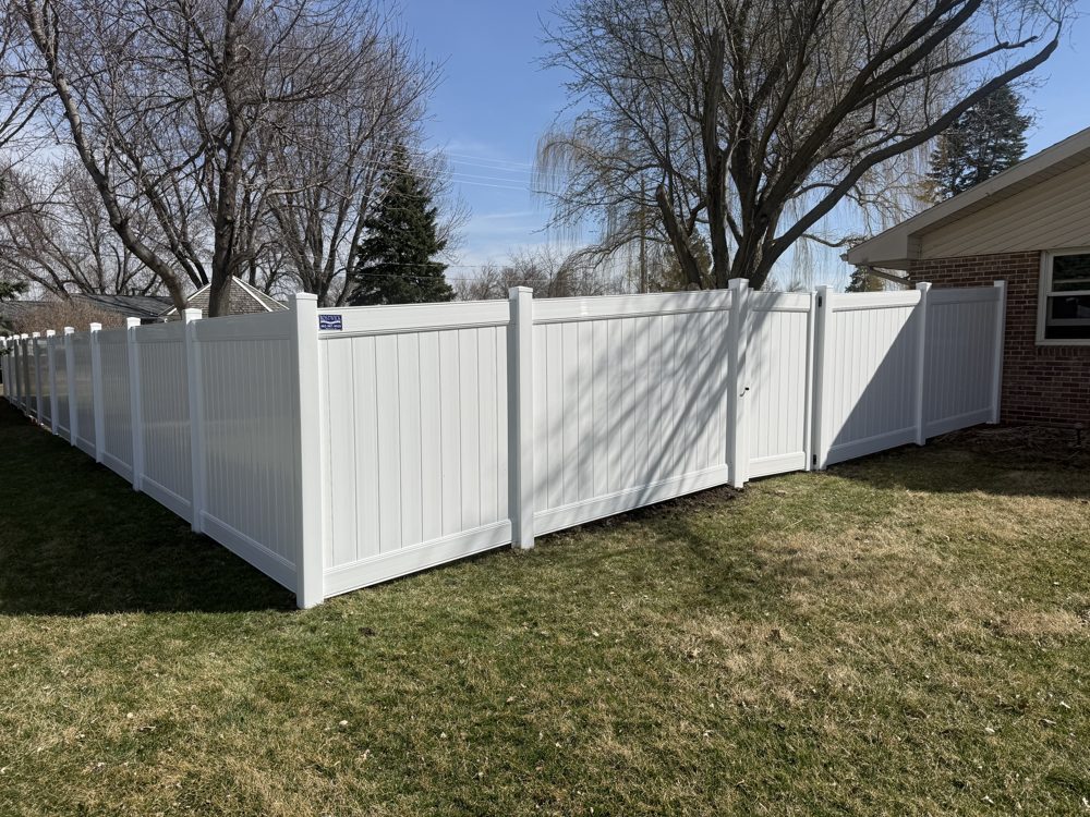 Black chain link fence installed along a sloped yard